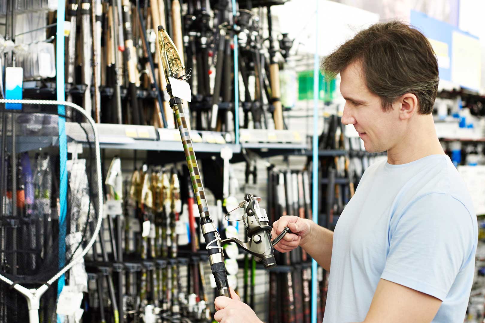 man shopping for fishing pole