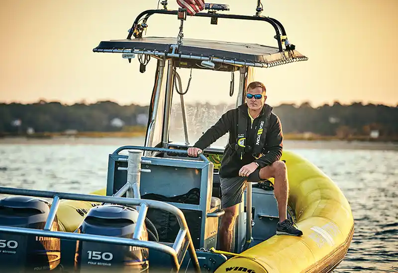 Sea Tow Captain on his patrol boat during sunset