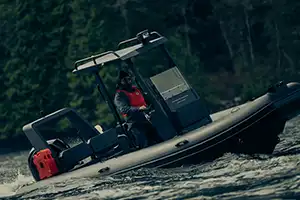 man driving boat wearing mustang survival life jacket